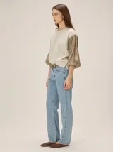 Remera blanca con cuerpo de algodón liso y mangas abullonadas semitransparentes con textura de lunares.
