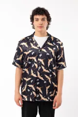 Camisa negra con estampado de grullas y flores, de manga corta y corte relajado, con cuello tipo sastre.