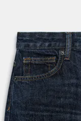 Jeans de tiro alto con corte barrel y diseño tapered, confeccionados en denim con efecto lavado y detalle de raya planchada. Presentan cintura con trabillas, cierre frontal con cremallera y botón, y bolsillos funcionales en delantero y espalda.