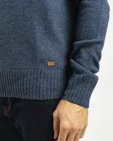 Buzo tejido de punto con cuello redondo, manga larga y puños y ruedo acanalados. Presenta un diseño clásico y versátil con un pequeño detalle de etiqueta en el lateral inferior.