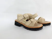 Sandalias bajas color beige con tiras anchas de cuero, ajuste con hebilla y suela track color negro.
