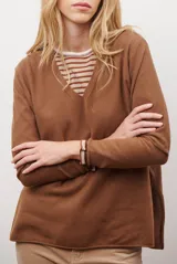 Sweater de tejido de punto color beige, con escote en V y mangas largas. Presenta un diseño básico y versátil de corte recto.