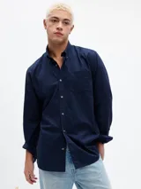 Camisa de popelina color azul marino, de corte estándar, con cuello abotonado, manga larga y bolsillo de parche en el pecho.