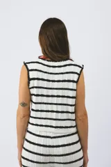 Chaleco tejido a rayas horizontales blancas y negras, con lazos delanteros.