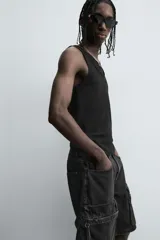 Camiseta sin mangas (tank top) negra, de corte slim fit, con cuello redondo de efecto doble.