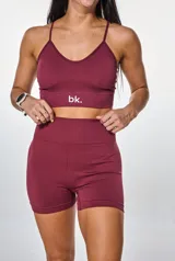 Conjunto deportivo compuesto por un top de breteles finos con logo estampado y un short de tiro alto, ambos en tejido de punto acanalado color bordó.