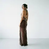 Falda larga de encaje rojo con diseño de volados laterales y transparencias, corte ajustado en la parte superior y fluido hacia el ruedo.