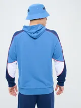 Canguro deportivo Umbro del Club Nacional de Football, modelo Nexo para hombre. Diseño en color azul marino con mangas rojas y detalles en celeste y blanco, capucha con cordón ajustable y bolsillo tipo canguro.