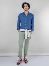 Pantalón chino azul marino de corte slim fit, confeccionado en gabardina con 77% algodón, 20% de algodón reciclado y 3% elastano. Presenta bolsillos delanteros y traseros. Tiene un lavado final con enzima ácida que le da un aspecto desgastado.