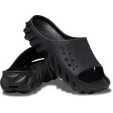 Chancla Crocs Echo Slide, completamente moldeada en color negro, con diseño esculpido y audaz, orificios de ventilación en la parte superior y suela con relieve ondulado.