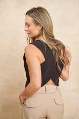 Chaleco negro con escote en V y cierre frontal con tres botones dorados.