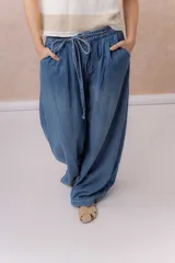 Jean de calce amplio y relajado, color azul, con pierna extra ancha y caída fluida. Diseño de tiro alto con pinzas delanteras y lazo regulable en la cintura. Cuenta con bolsillos laterales y traseros.