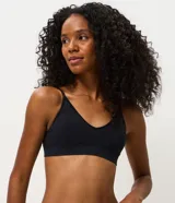 Soutien tipo top de diseño seamless, confeccionado en poliamida texturizada de color negro. Presenta base ancha, copas removibles y breteles finos regulables.