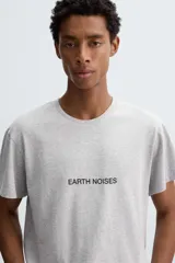 Camiseta de manga corta color gris jaspeado, corte slim fit, con cuello redondo y texto estampado en negro en el pecho que dice "EARTH NOISES".