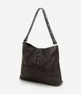 Cartera estilo hobo de cuero sintético en color gris oscuro, con diseño de media luna y correa fija para el hombro. Cuenta con bolsillos frontales funcionales, detalles de ojalillos metálicos plateados y un cordón cruzado ajustable con lazo en el centro.