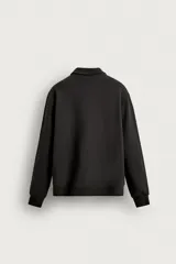 Sudadera polo de corte regular, confeccionada en tejido técnico interlock de algodón con elasticidad. Presenta cuello solapa, cierre frontal de cremallera y manga larga con puños acabados en rib.