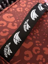 Bolso térmico cuadrado de gran capacidad, color negro con estampado en blanco de sirenas y motivos marinos. Posee asas de mano y una correa ajustable estampada con el monograma de la marca.