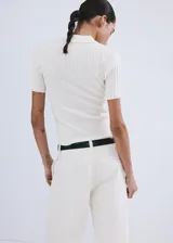 Chaleco de tejido de punto fino y diseño entallado, con cuello camisero, escote en V y mangas cortas.