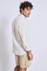 Camisa de corte regular con diseño de rayas verticales finas en tonos claros, cuello clásico y mangas largas con puños abotonados.