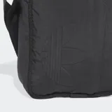 Bolso tipo morral Adidas de diseño minimalista, color negro, confeccionado en nylon reciclado. Presenta el logotipo del Trifolio en relieve en el frente, cierre de cremallera y correa ajustable para llevar al hombro o cruzado.