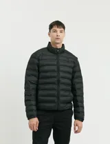 Campera capitoneada de poliéster con cierre frontal al tono y bolsillos laterales con cierre invisible.
