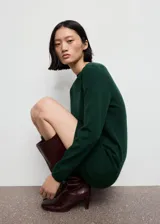 Vestido corto de punto fino, color verde oscuro, con cuello redondo, diseño recto y manga larga.