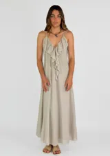 Vestido largo blanco de tirantes finos, con escote en V profundo y detalle de volados en el frente. Diseño fluido y ligero.