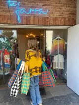 Bolso tejido con patrón de damero en varios colores, con asas de tela.