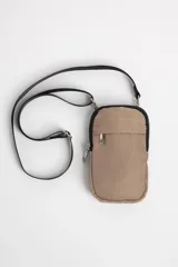 Bandolera porta celular color beige con correa larga negra ajustable.