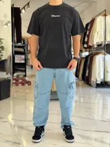 Remera oversize gris con efecto acid wash, de mangas cortas y cuello redondo, con estampado tipográfico blanco en la espalda.