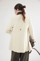 Tapado corto de paño de lana en color celeste, con cuello mao en pana marrón, botones forrados en contraste y cinta de terciopelo aplicada. Presenta una silueta entallada con bolsillos delanteros.