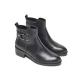 Bota corta de diseño urbano confeccionada en símil cuero liso, con punta redondeada y taco medio recto. Presenta un detalle lateral con tira, hebilla metálica y apliques decorativos, además de una tira trasera para facilitar el calce y cierre interno.