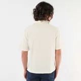 Camisa de manga corta color blanco con diseño texturizado, cuello cubano y cierre frontal de botones.