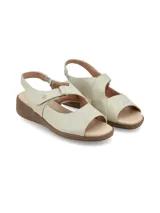 Sandalia de cuero color crema, con puntera descubierta, tira ancha sobre el empeine con ajuste de velcro, talón descubierto con tira ajustable y suela marrón de goma.