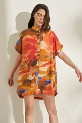 Vestido corto de lino blanco con estampado artístico de paisaje costero, cuello mao y mangas cortas holgadas.