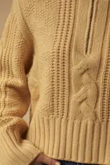 Sweater tejido color crema con cuello alto y cierre metálico frontal parcial.