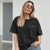 Remera oversize de algodón con acabado stonewash y efecto desgastado, con logo ovalado retro estampado en la espalda.