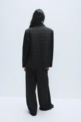 Pantalón de tiro alto con diseño a cuadros, pernera recta y trabillas para cinturón. Cuenta con bolsillos laterales y cierre frontal con cremallera, botón oculto y gancho metálico.