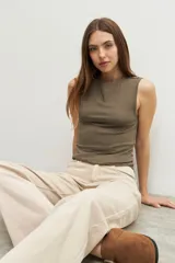 Musculosa verde oliva con cuello redondo y botones decorativos en los hombros.
