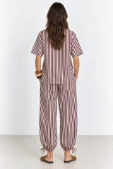Pantalón de algodón a rayas borra de vino y blancas, de corte holgado estilo globo con cintura elástica, bolsillos laterales y detalle de ajuste con cordón en los tobillos.