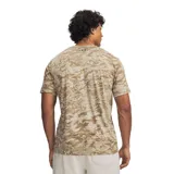 Remera de manga corta Under Armour con estampado de camuflaje en tonos marrones y caqui, cuello redondo y el logotipo de la marca en negro en el pecho.