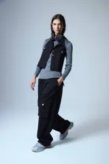 Pantalón cargo de denim negro, con cintura elástica y grandes bolsillos cargo a los lados con botones metálicos plateados.