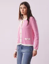 Cardigan de tejido tweed celeste y blanco, con escote redondo, cierre frontal con botones metálicos dorados y bolsillos simulados en el frente.