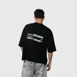 Remera negra de corte oversize con mangas cortas amplias y cuello redondo. Presenta un pequeño estampado minimalista en color blanco en el pecho.