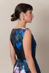 Vestido italiano azul con estampado floral en tonos rosa, blanco y verde. Presenta detalle de encaje en el escote, corte a la cintura y falda con tablas.