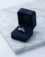 Anillo de plata 925 con diseño calado y piedra facetada azul en forma ovalada.