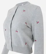 Cardigan corto de punto color gris, con cuello redondo, mangas largas y cierre frontal con botones. Presenta un diseño ajustado al cuerpo con bordados de cerezas distribuidos por toda la prenda.