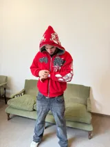Campera reversible con cierre frontal, confeccionada en algodón de alto gramaje con estampa plastisol y bordado con aplique en un lado, y tela polar de pelo largo en el reverso. Presenta diseño oversize, capucha integrada y puños acanalados.