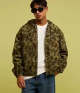 Campera con capucha y cierre frontal, confeccionada en sarga con estampado camuflado. Tiene manga larga con sisa desplazada, puños ajustados, bolsillo canguro y bajo con elástico.