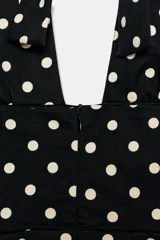 Vestido mini con cuello halter y escote en pico. Presenta un diseño con falda acampanada y cierre posterior con cremallera oculta.
